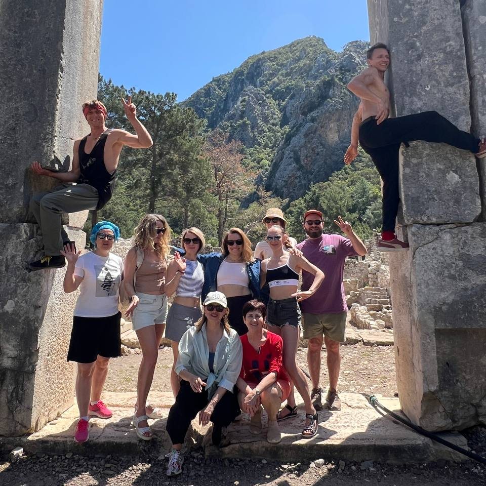 The group together among ancient stone columns at Çıralı