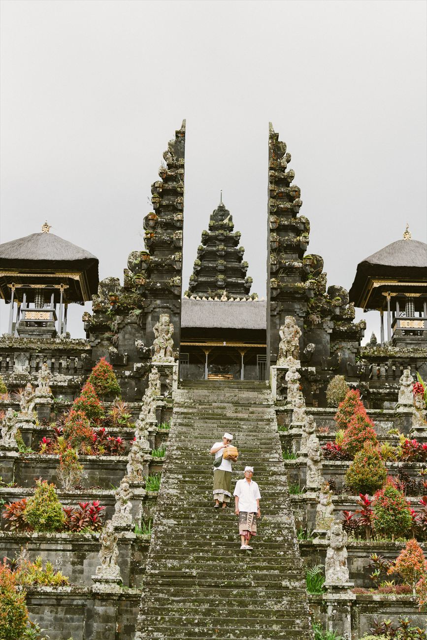 Wide stone stairs rising to a Balinese temple gate
