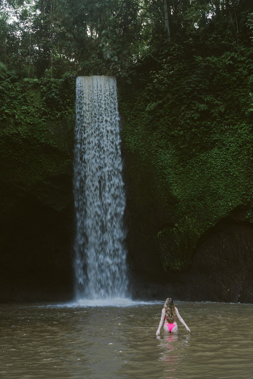 Swimming at the foot of a jungle waterfall