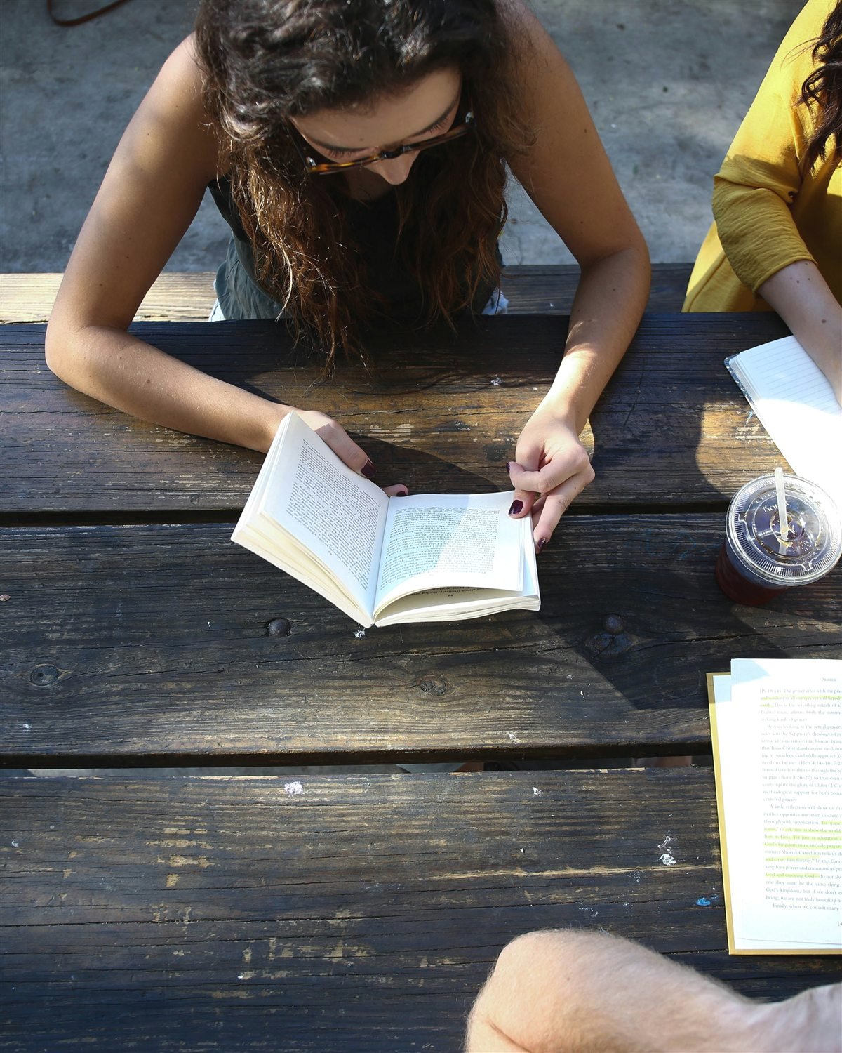 People working together around a wooden table with books and notebooks