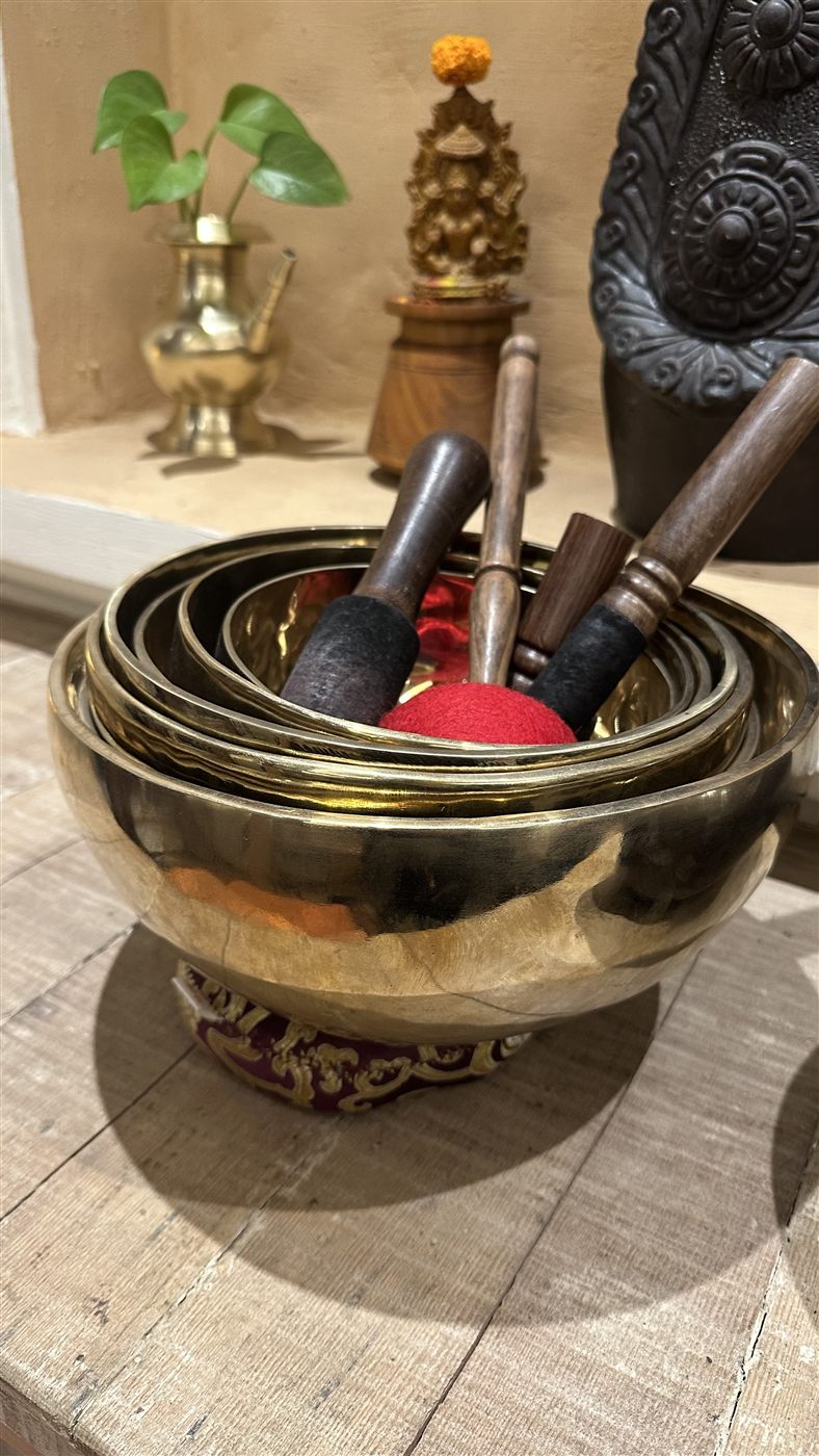 Brass Tibetan singing bowls nested together with their mallets, close up