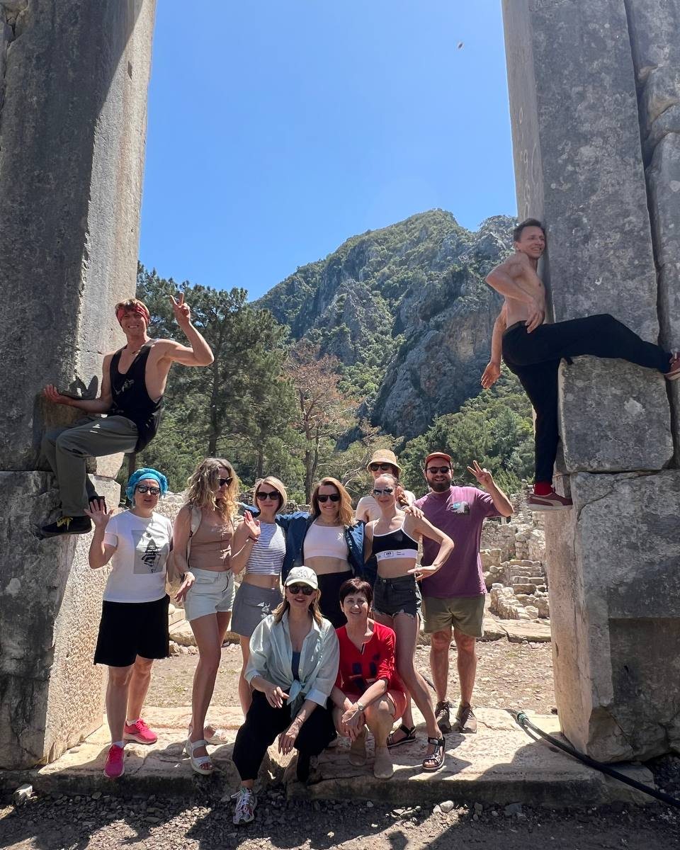 The group together among ancient stone columns at Çıralı