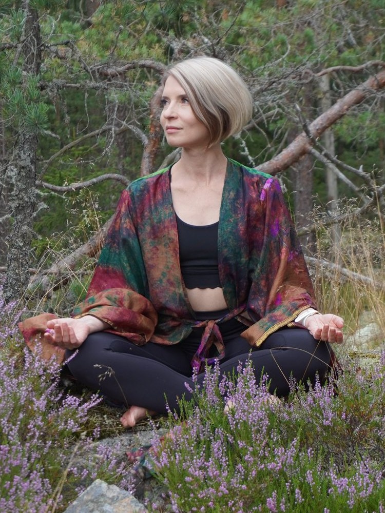 Natasha seated in a Finnish forest among flowering heather